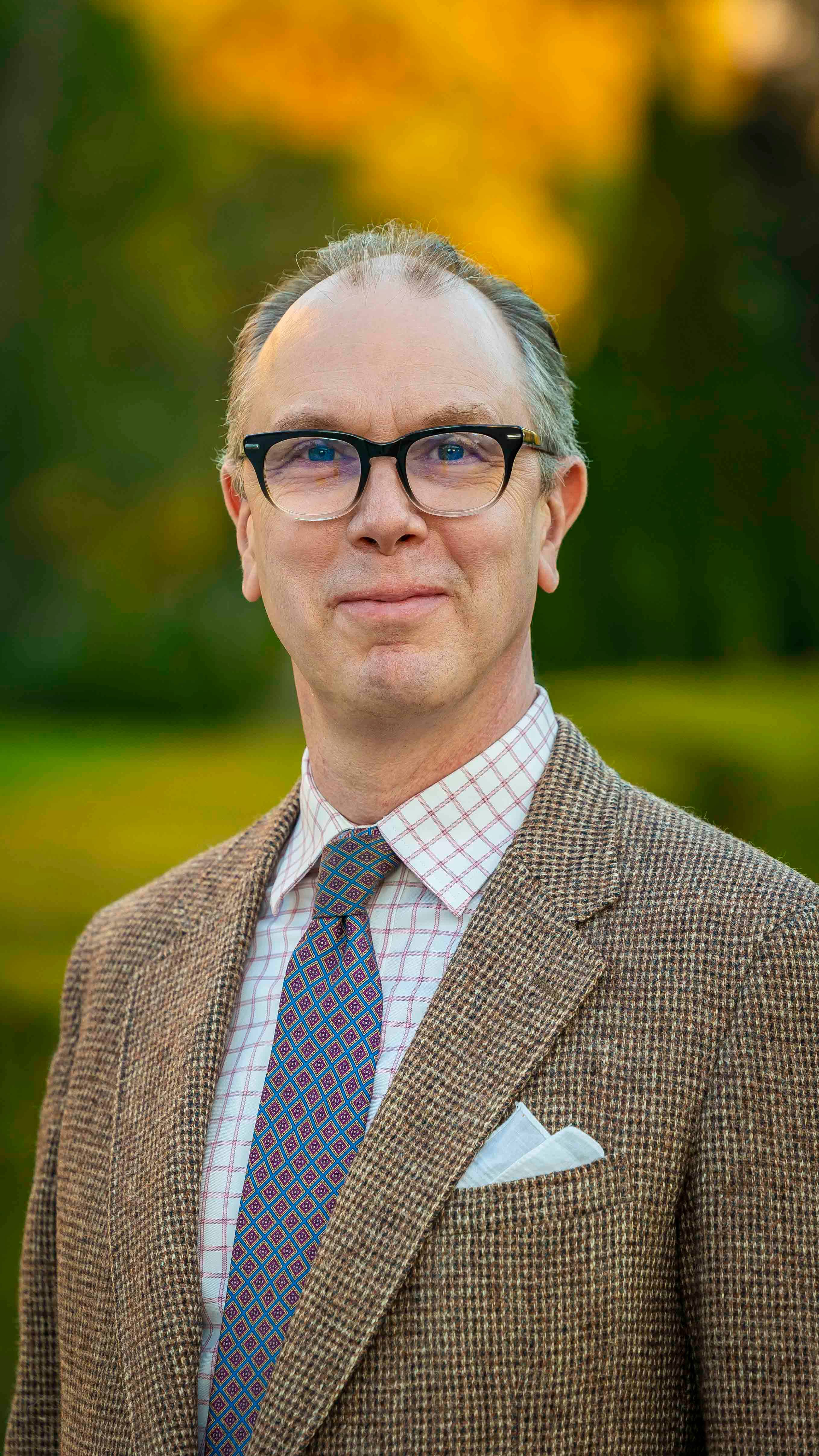 a person wearing glasses and a suit