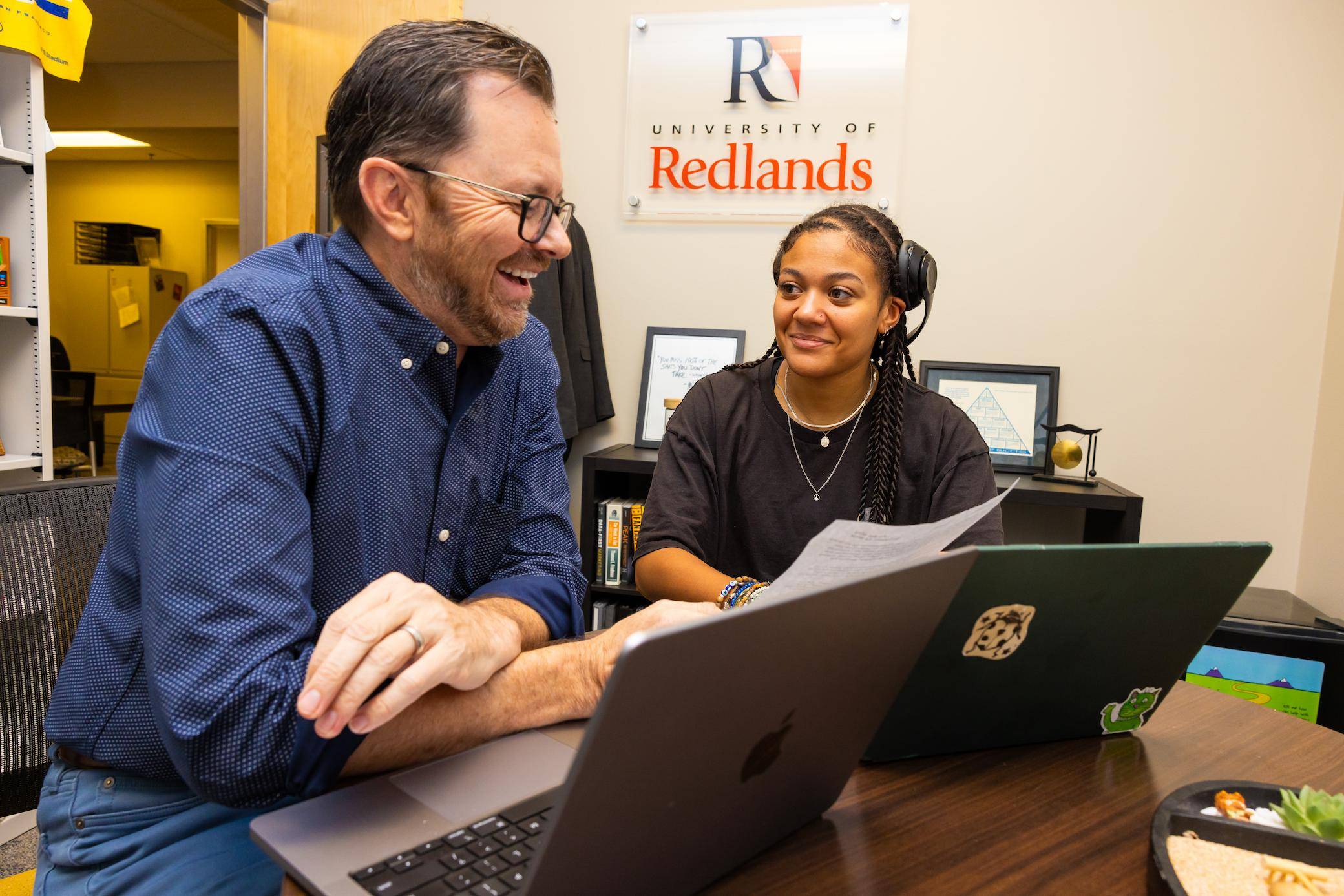 a person and person looking at a laptop