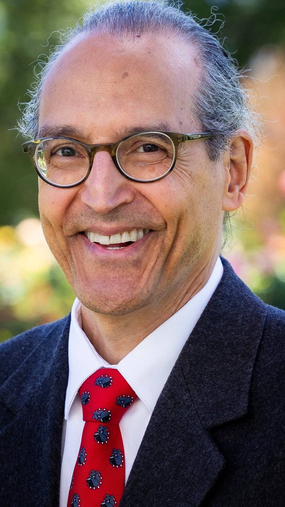 a person wearing glasses and a suit