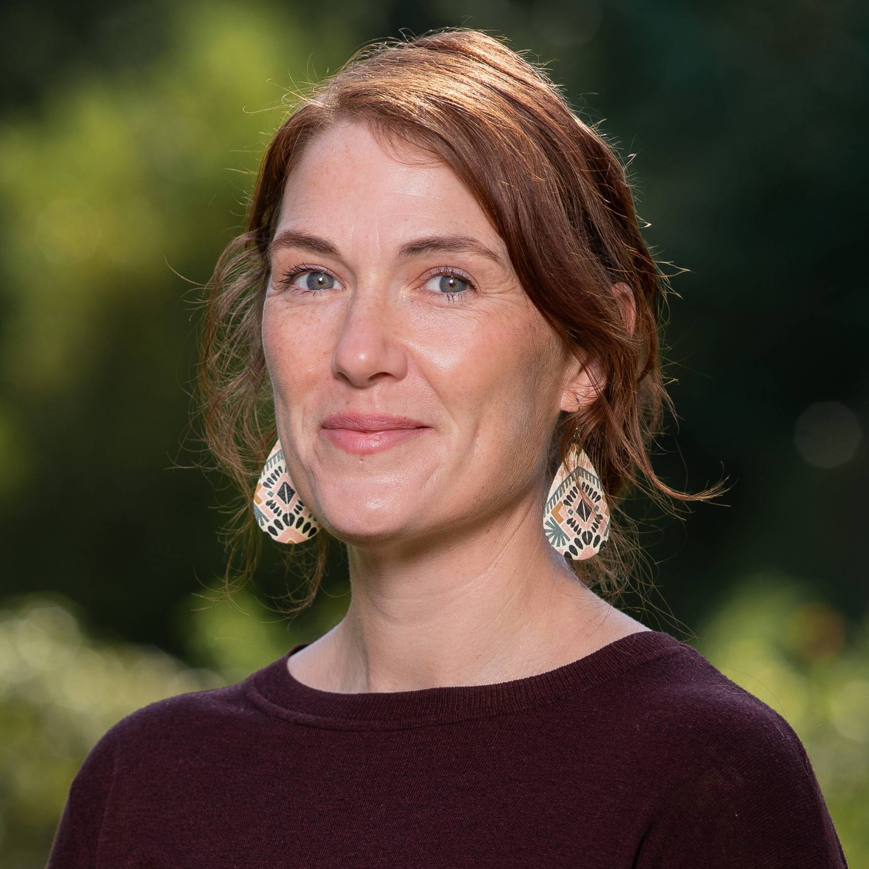 a person with red hair wearing earrings