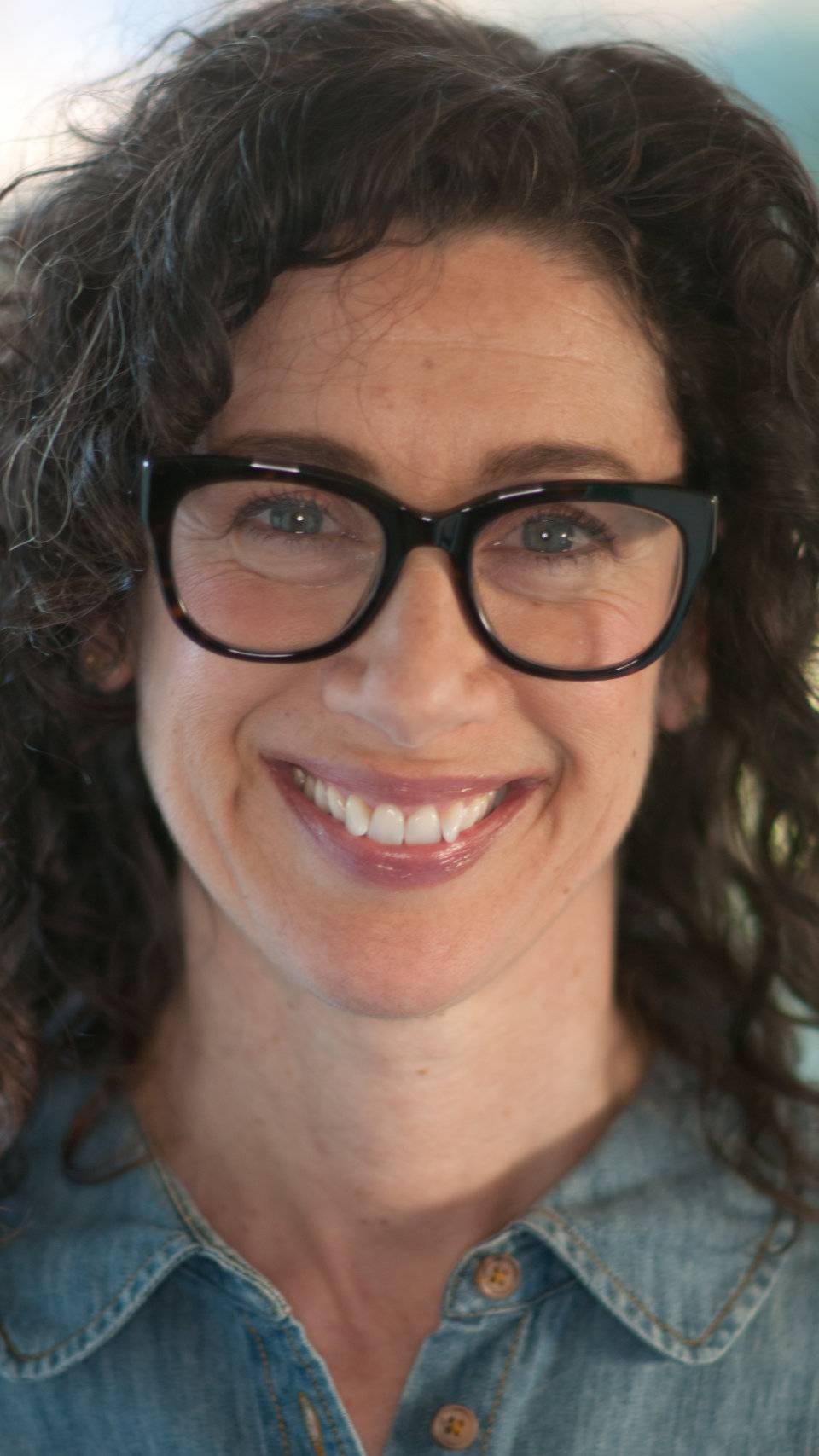 a person wearing glasses smiling