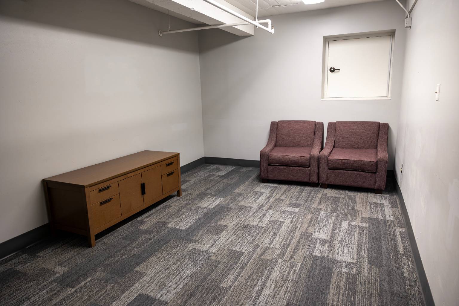a room with two chairs and a cabinet