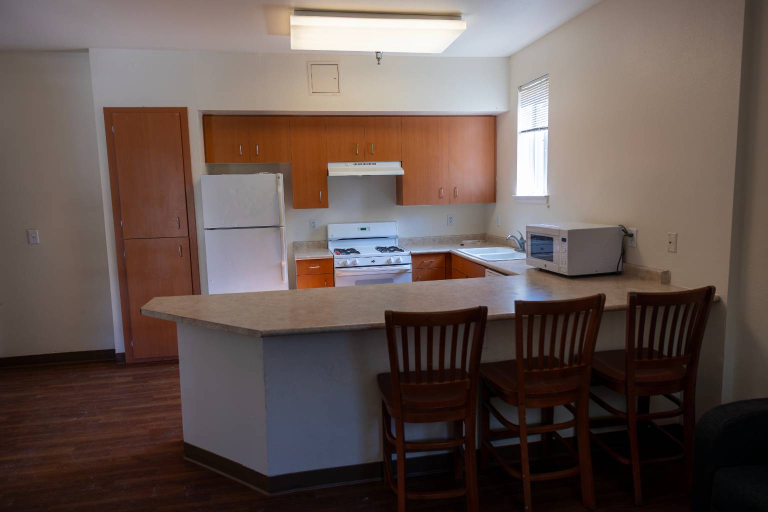 a kitchen with a bar and chairs