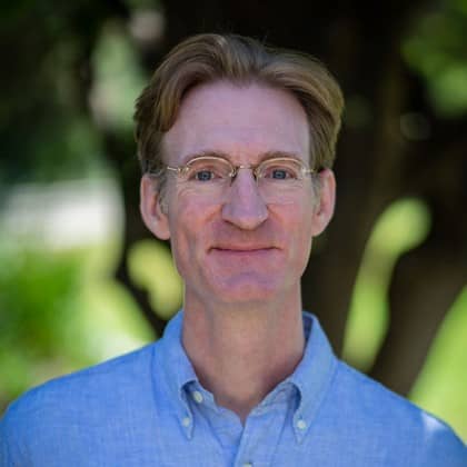 a person wearing glasses and a blue shirt