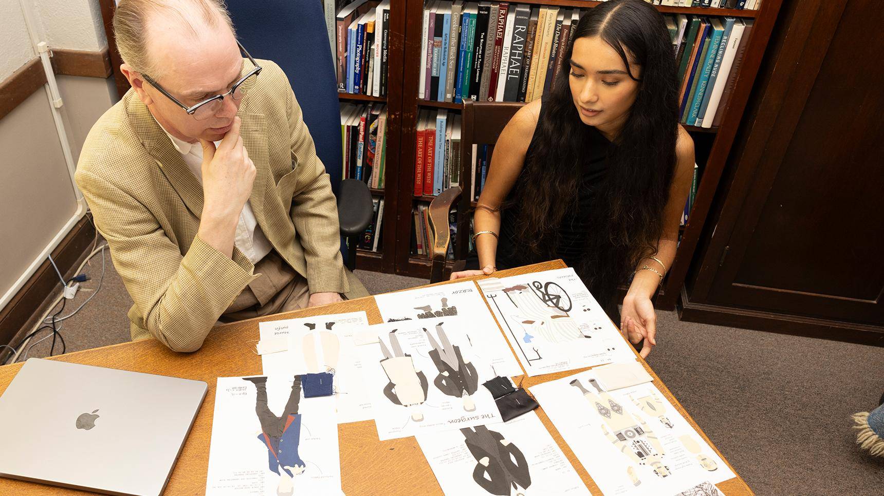 a person and person looking at a table with paper