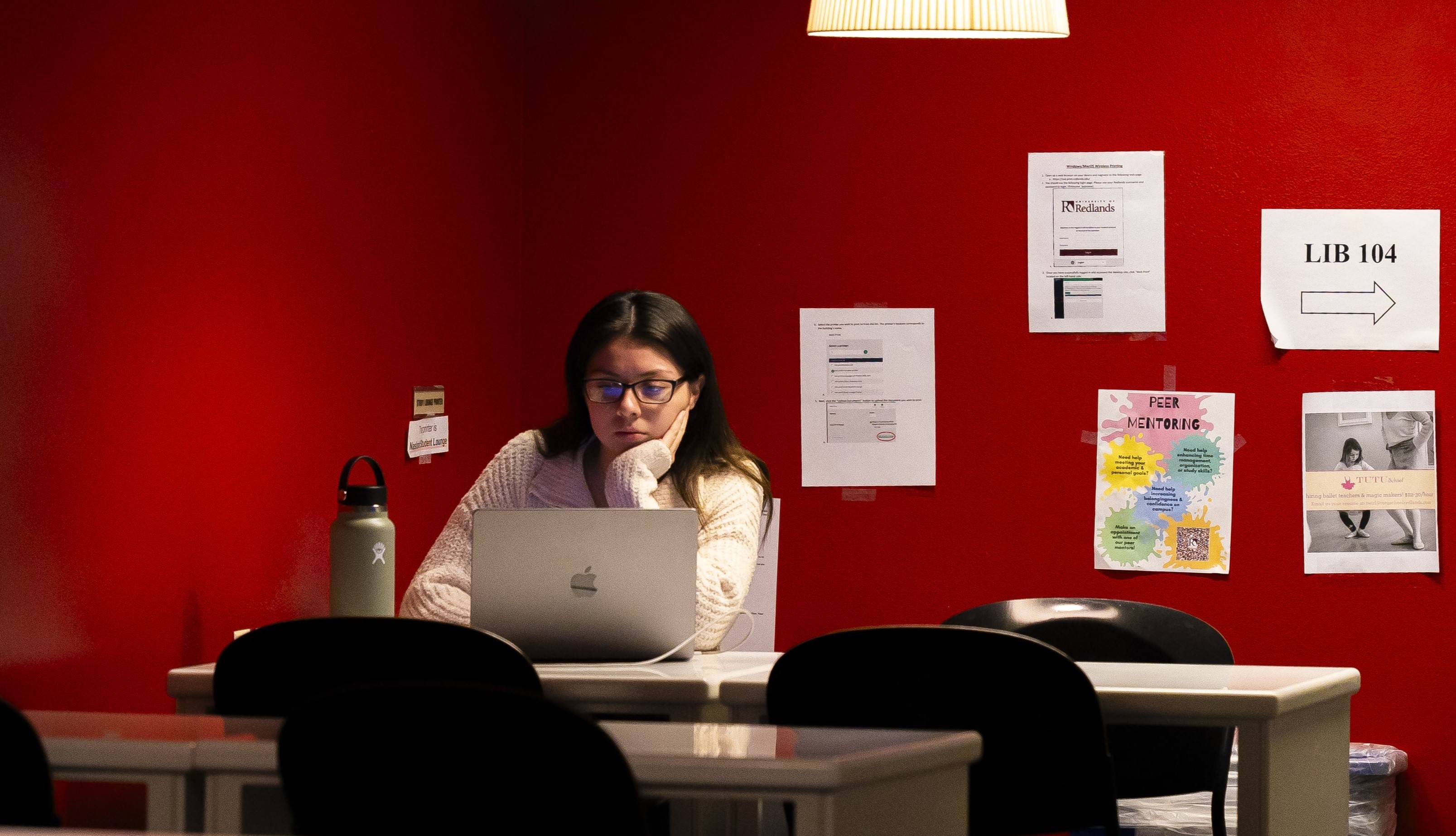 a person sitting at a table with a laptop