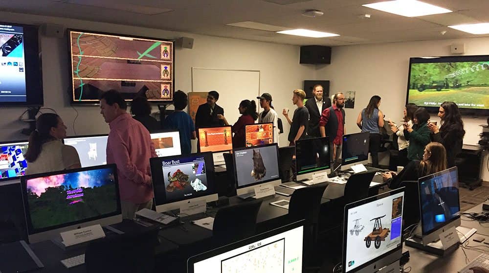 a group of people standing in front of computers