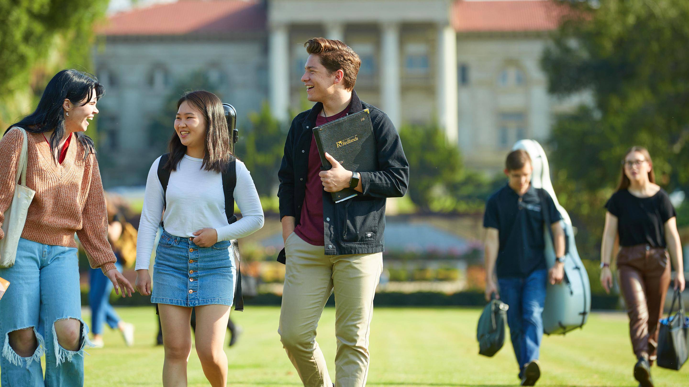 a group of people walking on a grass field
