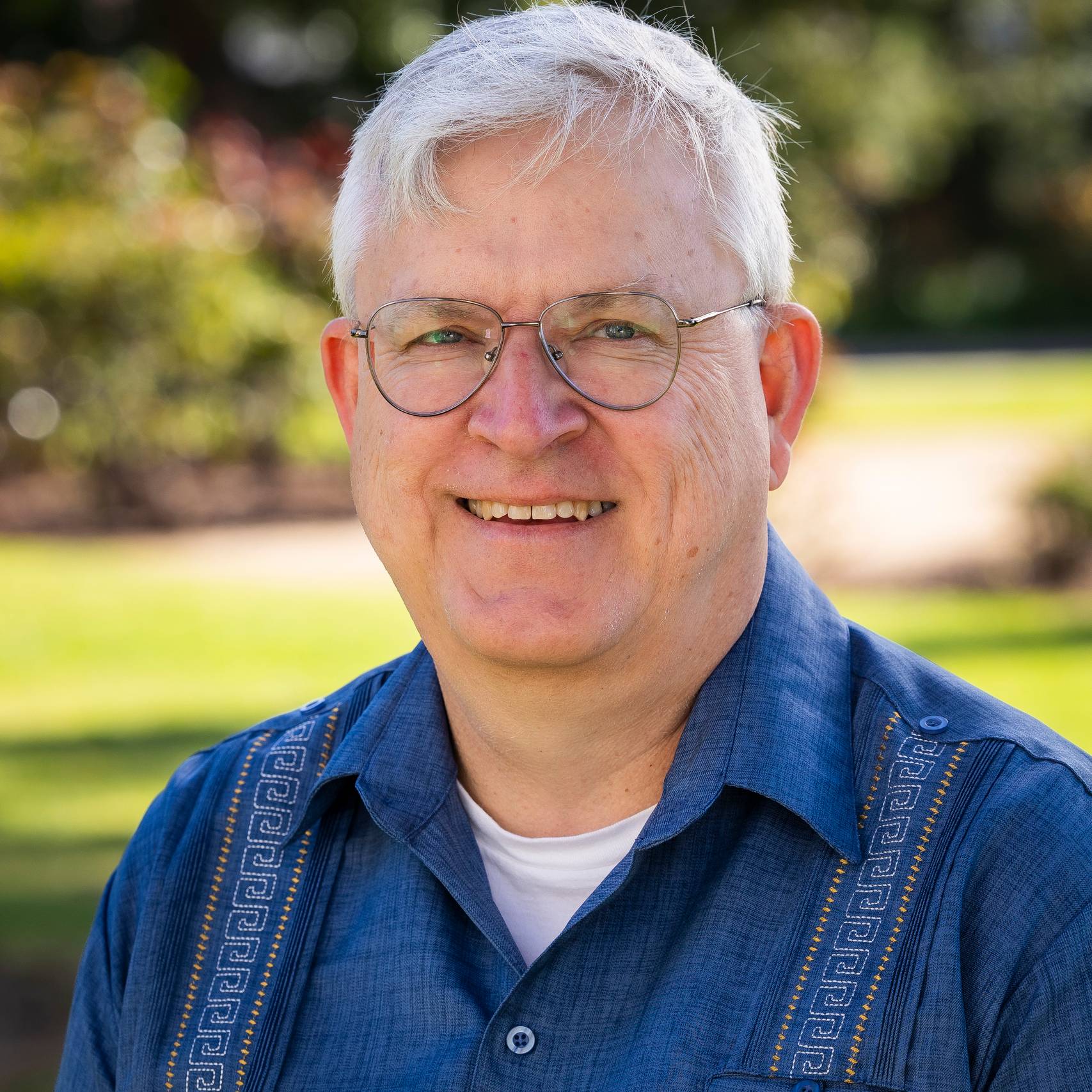 a person wearing glasses and smiling