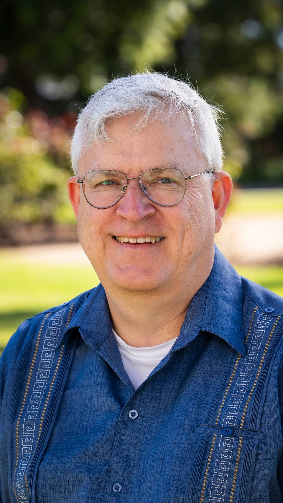 a person wearing glasses and smiling