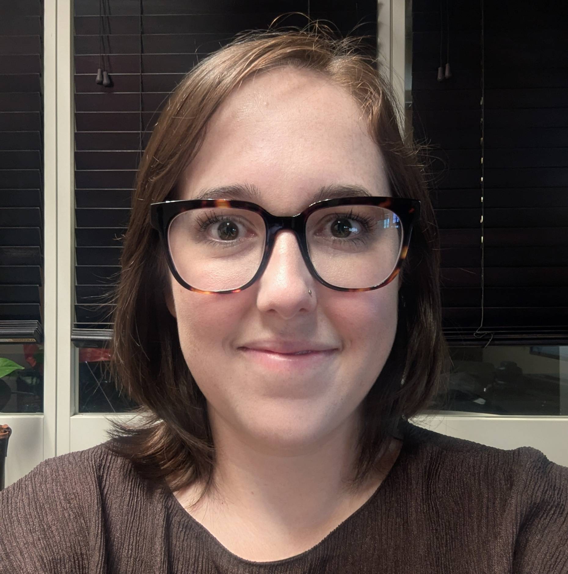 a person wearing glasses smiling