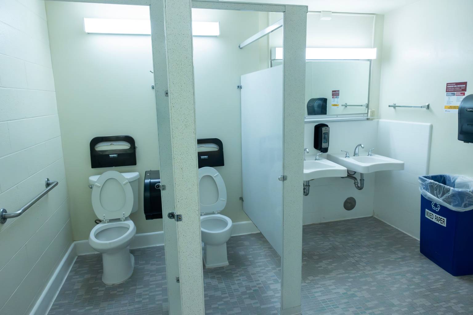 a bathroom with two toilets and sinks