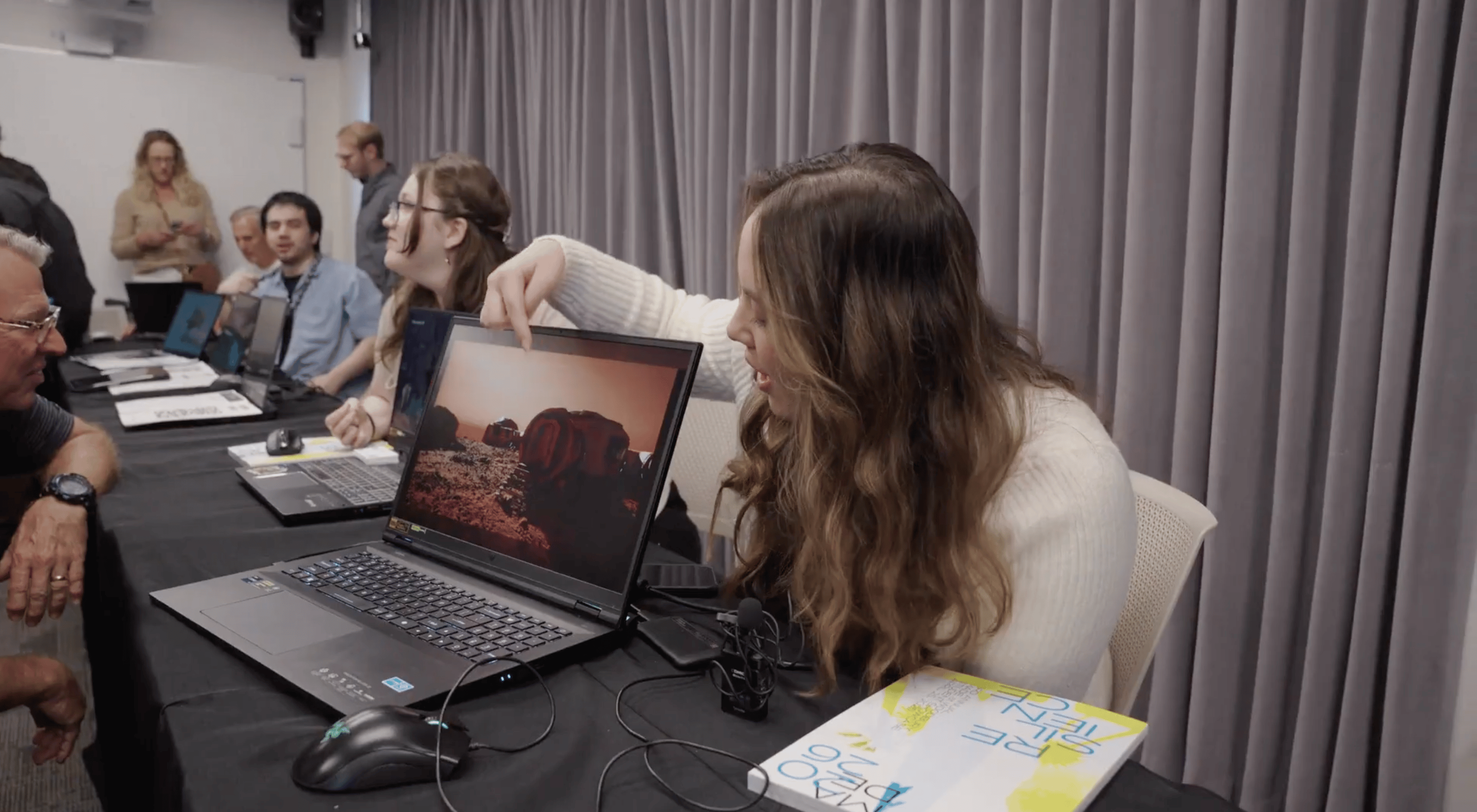 a person pointing at a laptop