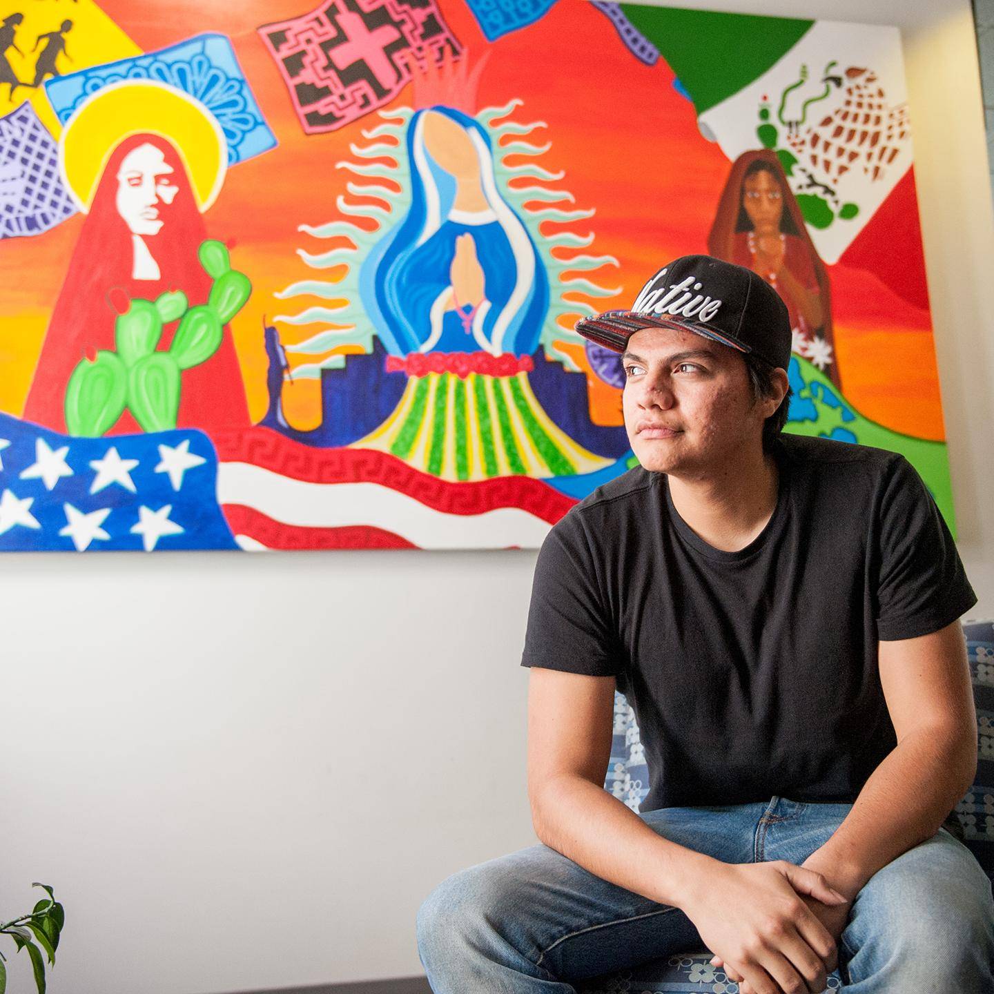 a person sitting in front of a colorful painting