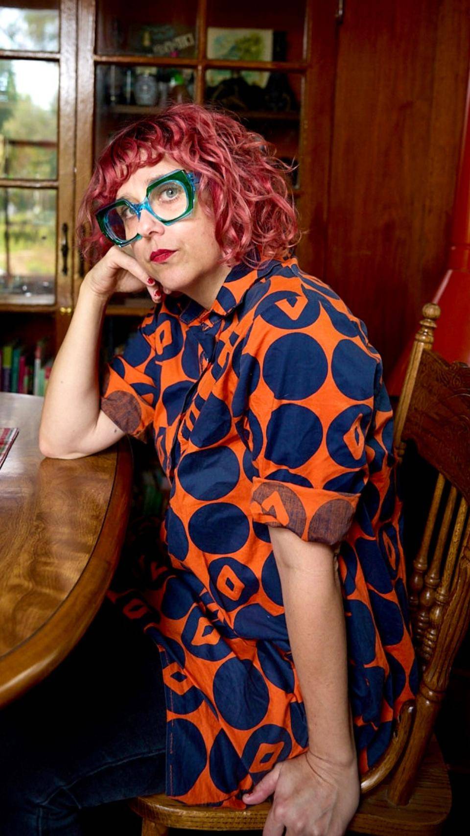 a person sitting at a table with her hand on her face