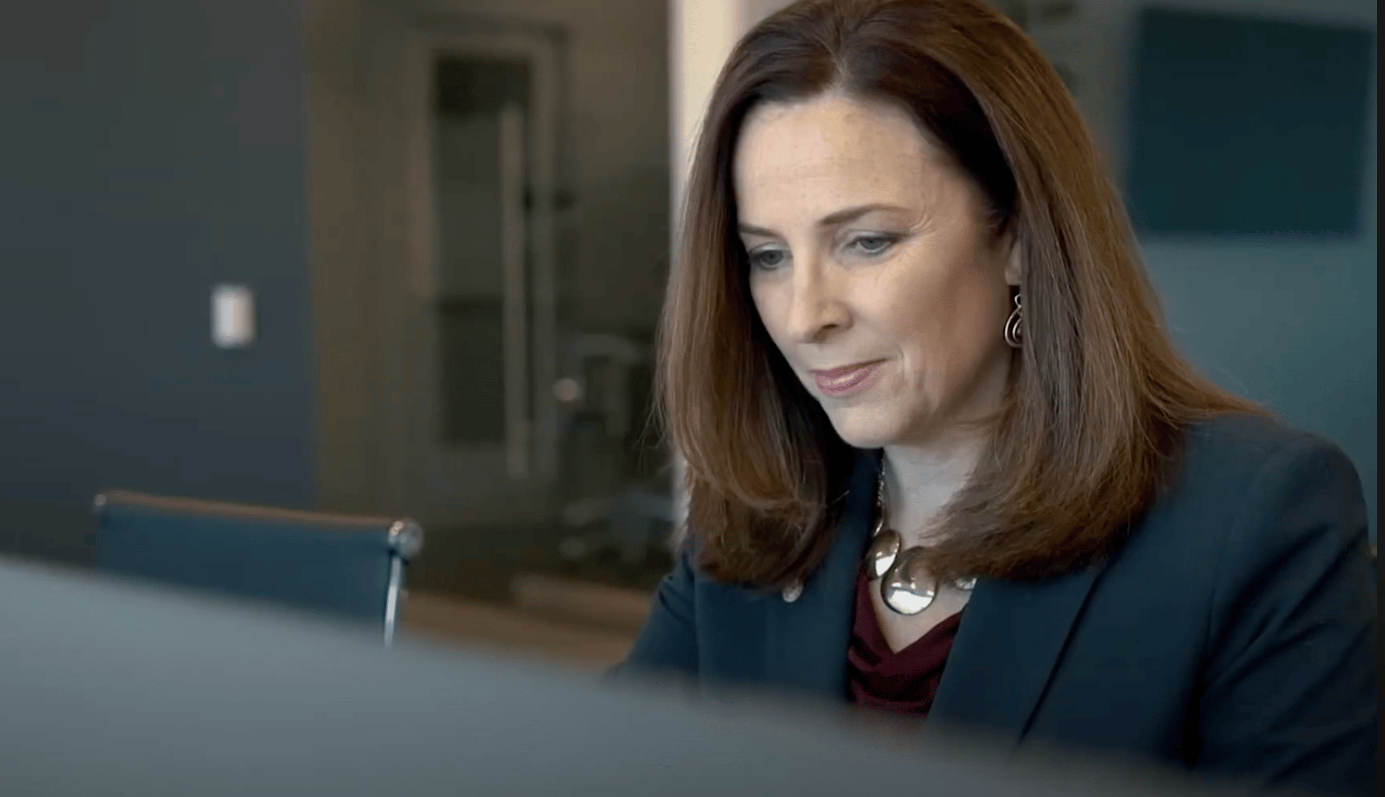 a person looking down at a computer screen