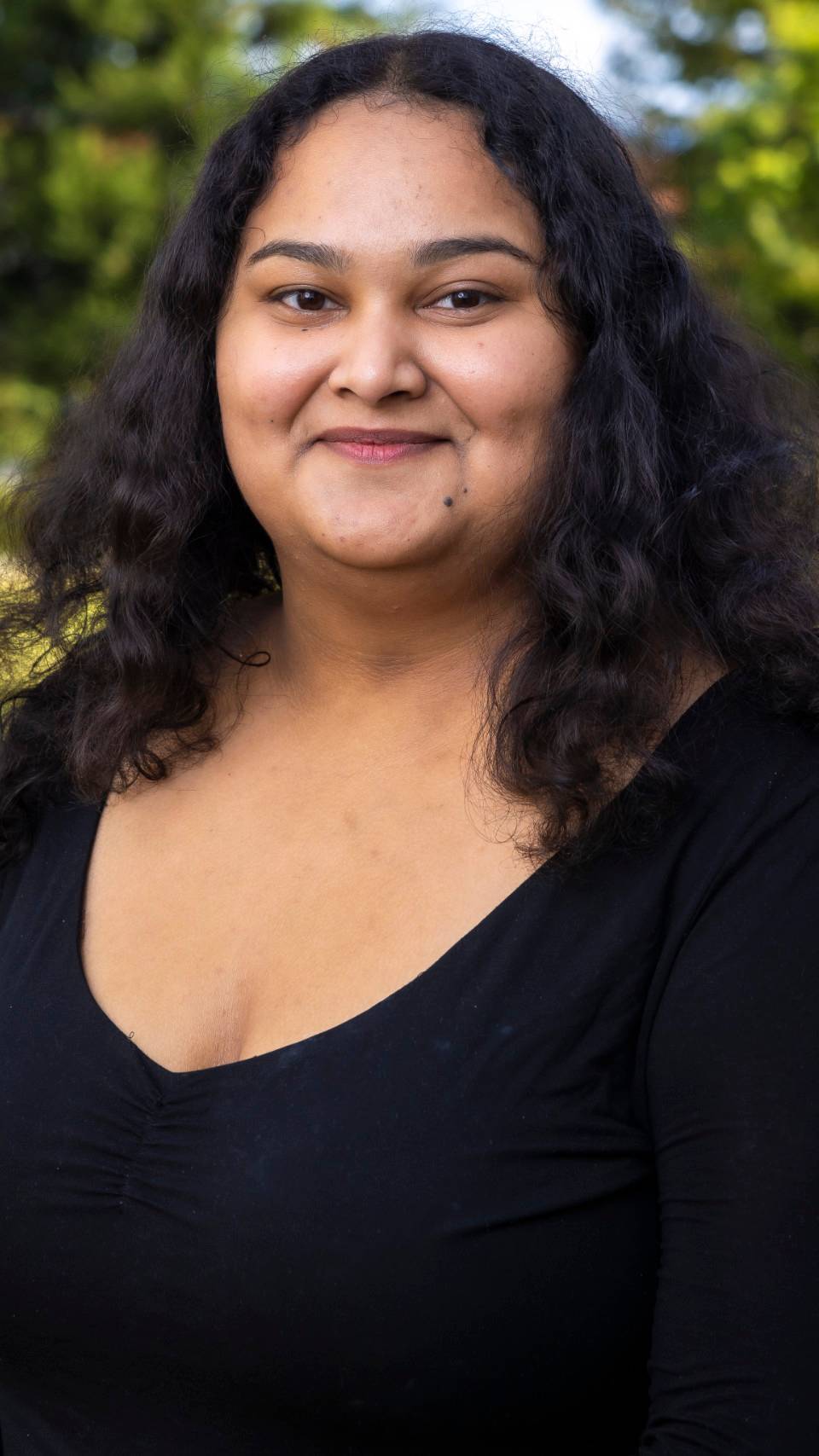 a person with long curly hair wearing a black shirt