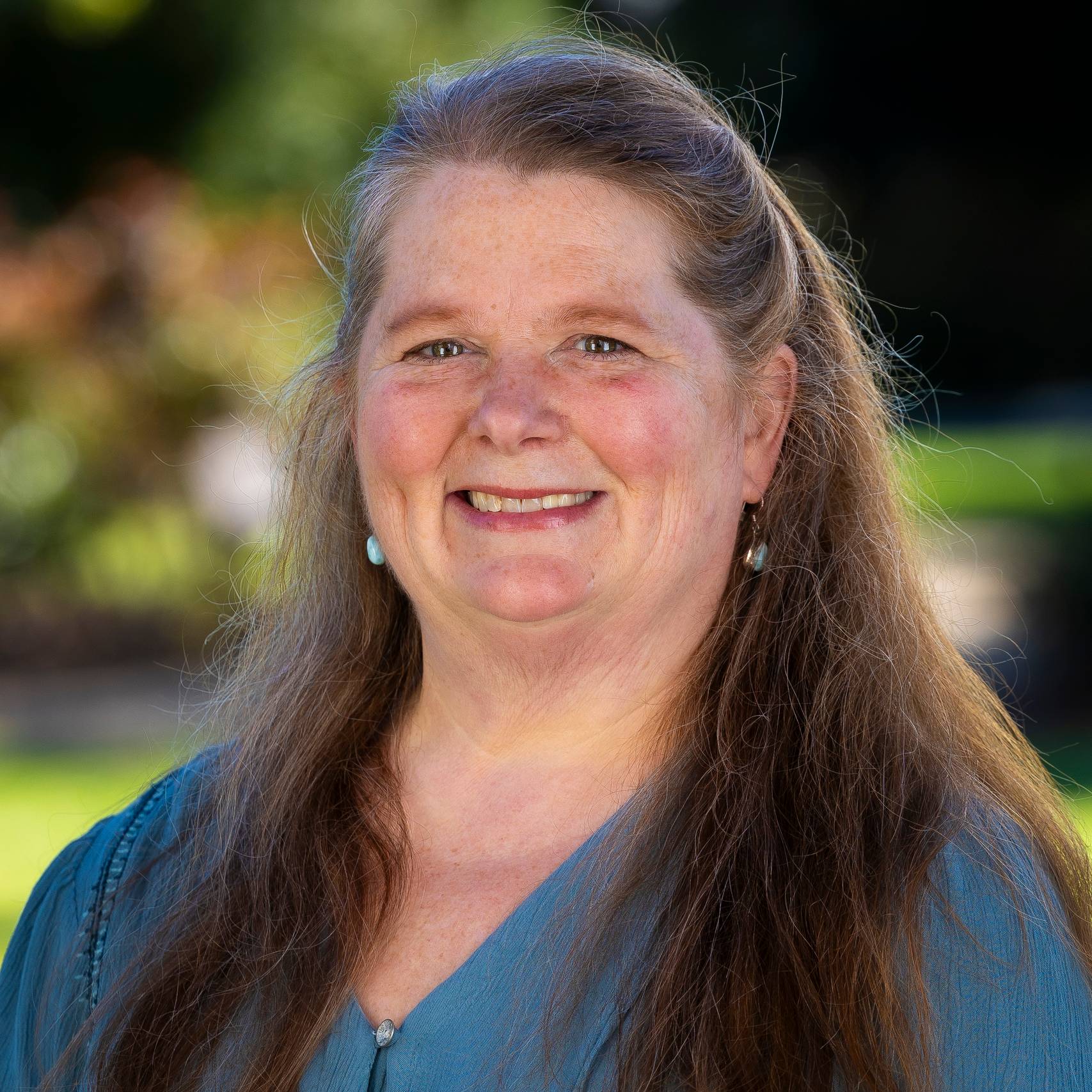 a person with long hair smiling