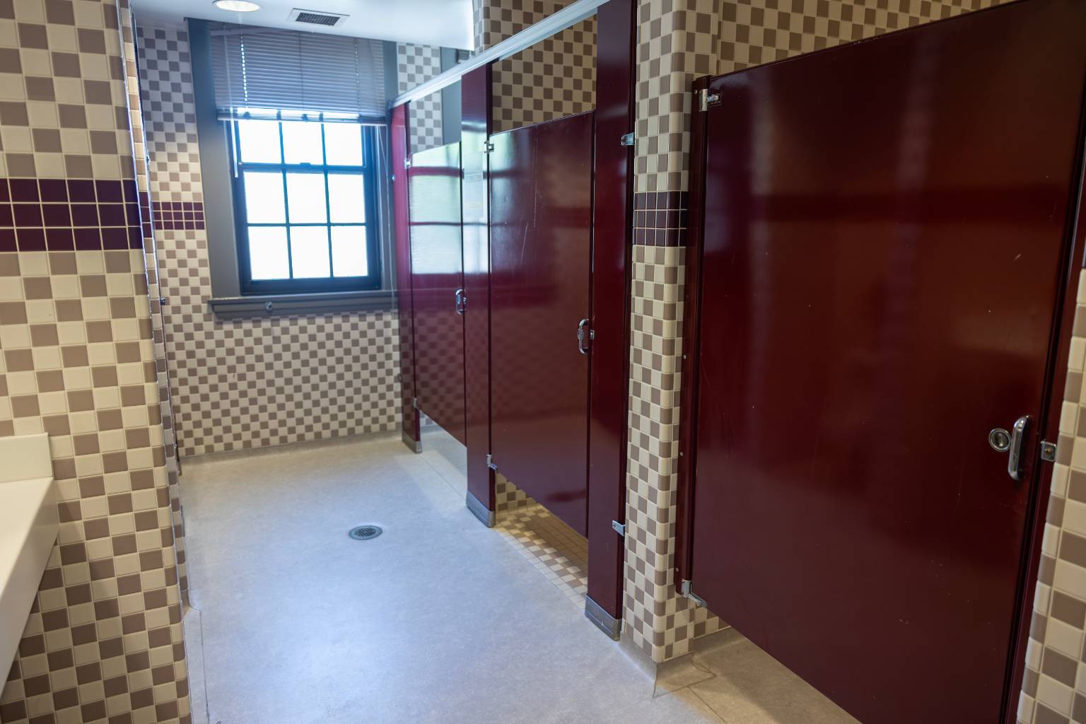 a bathroom with red doors and a window
