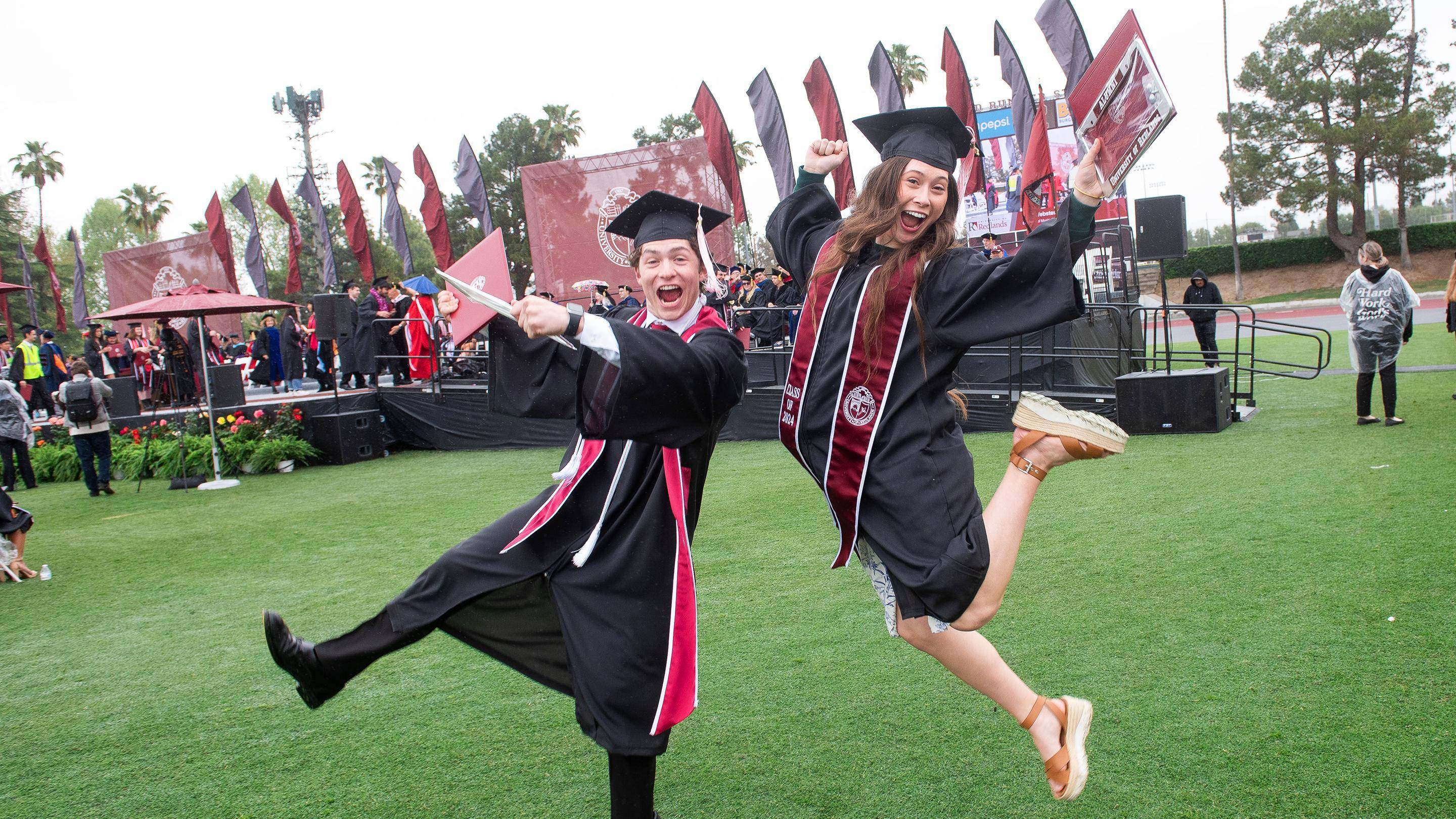 a person and person in graduation gowns jumping in the air