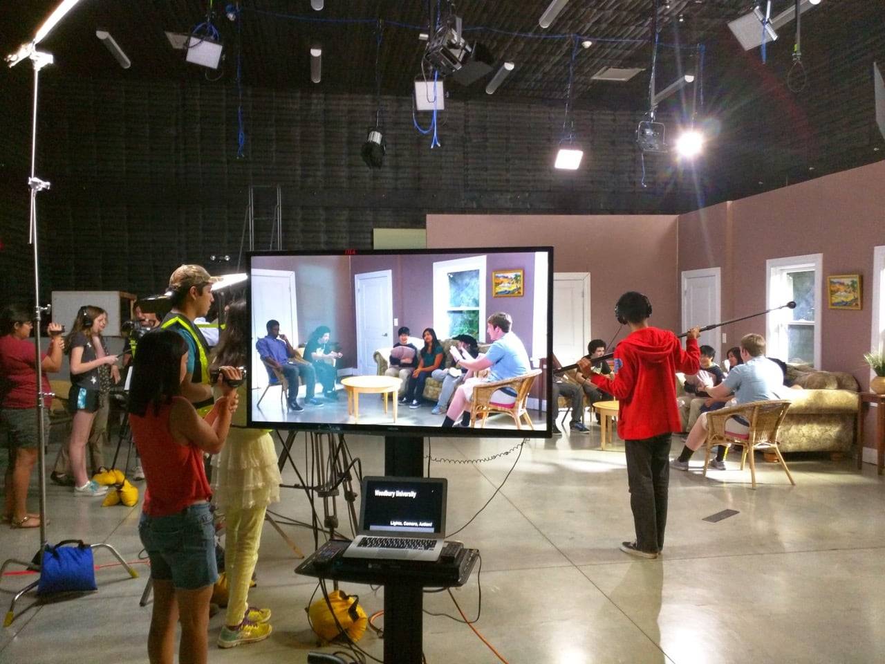 a group of people in a room with a large screen