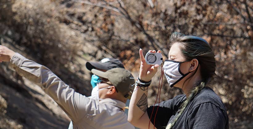 a person wearing a face mask and holding a compass