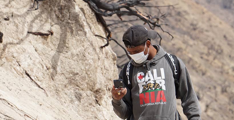 a person wearing a mask and looking at a phone