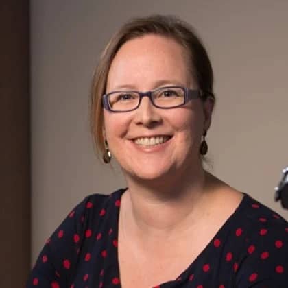a person wearing glasses and smiling