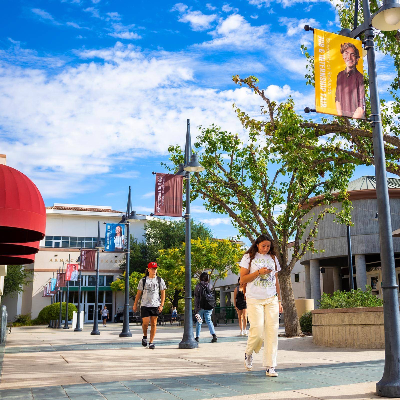 a group of people walking on a sidewalk