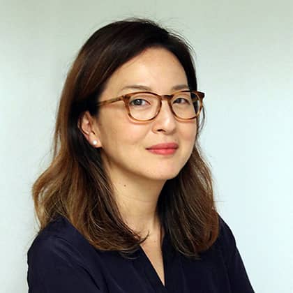 a person wearing glasses and smiling