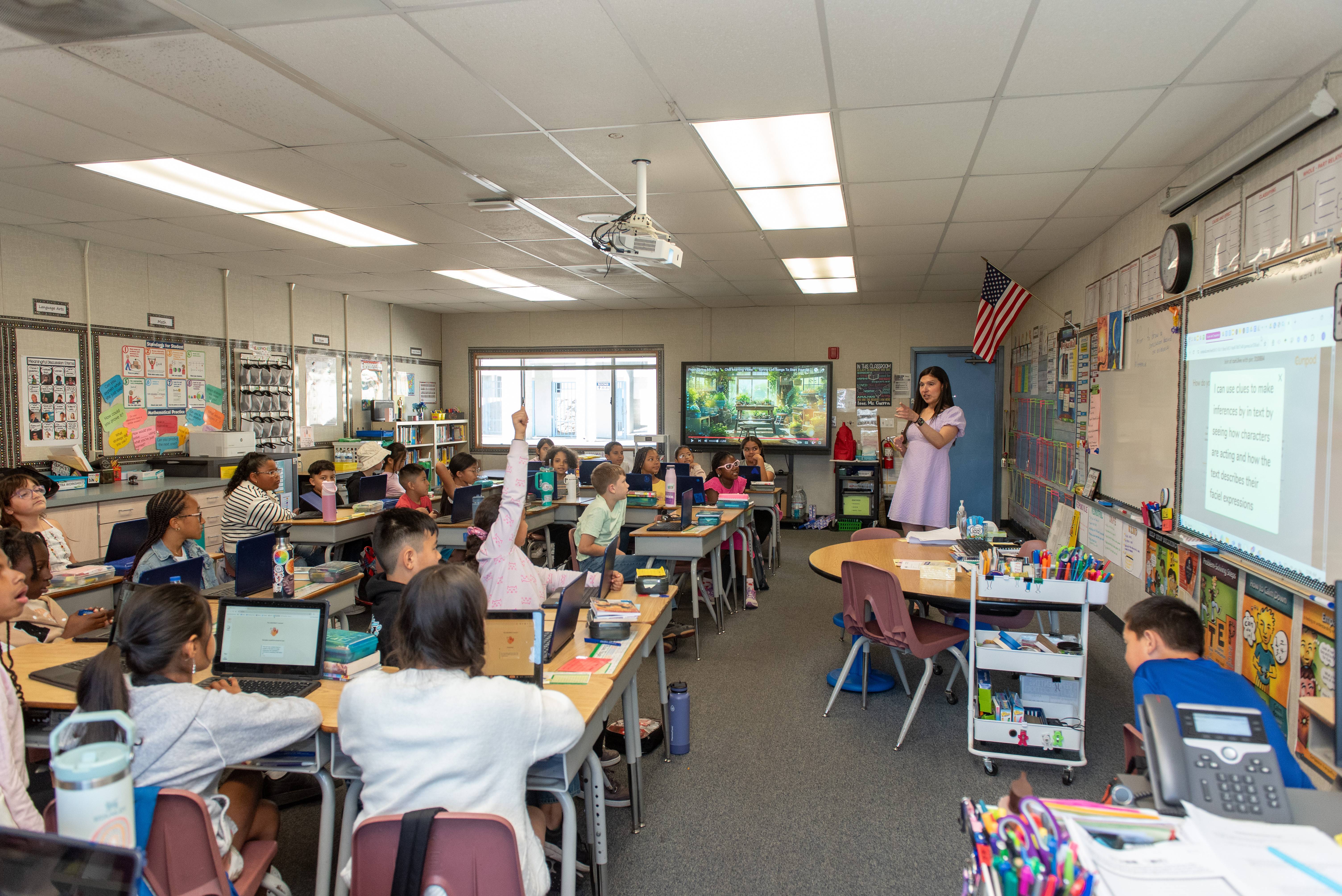 a person standing in front of a group of students in a classroom