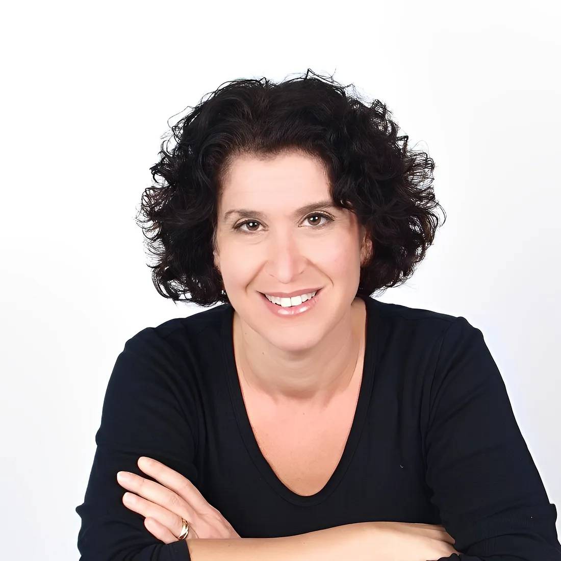 a person with black hair and arms crossed