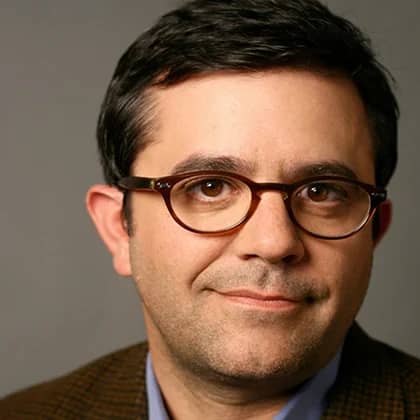 a person wearing glasses and a brown jacket