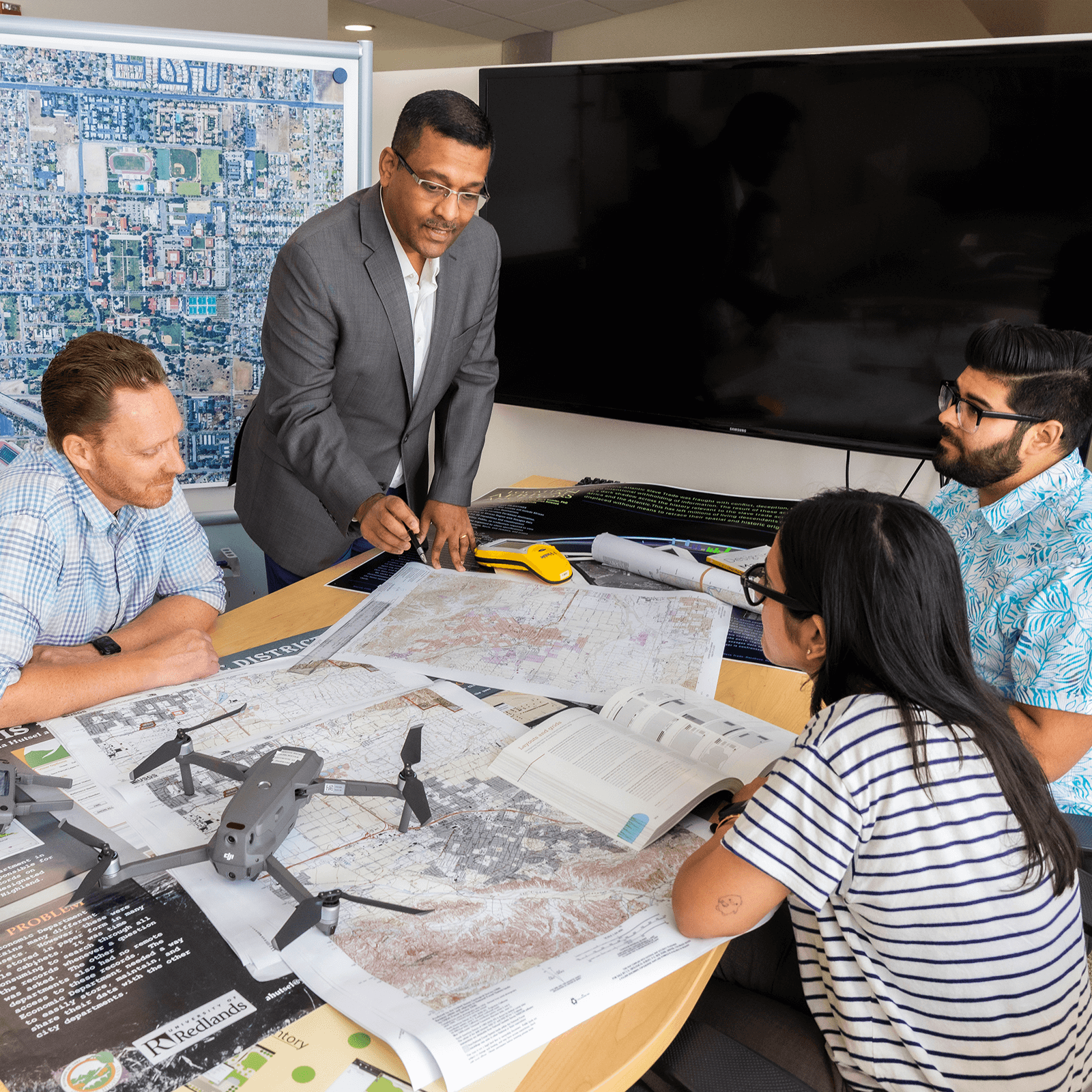 A group of researchers around a table with a drone