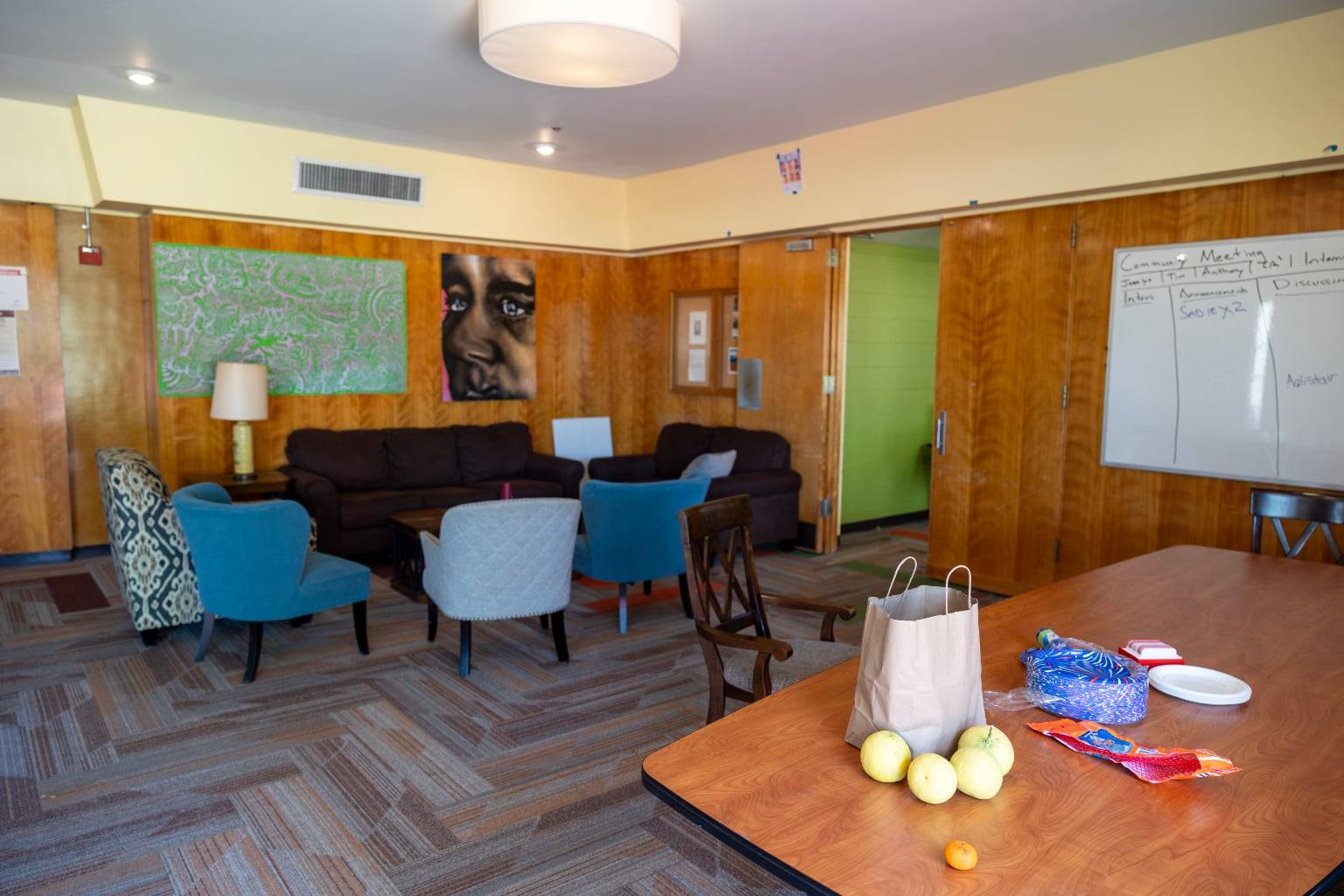 a room with a table and chairs and a bag of food