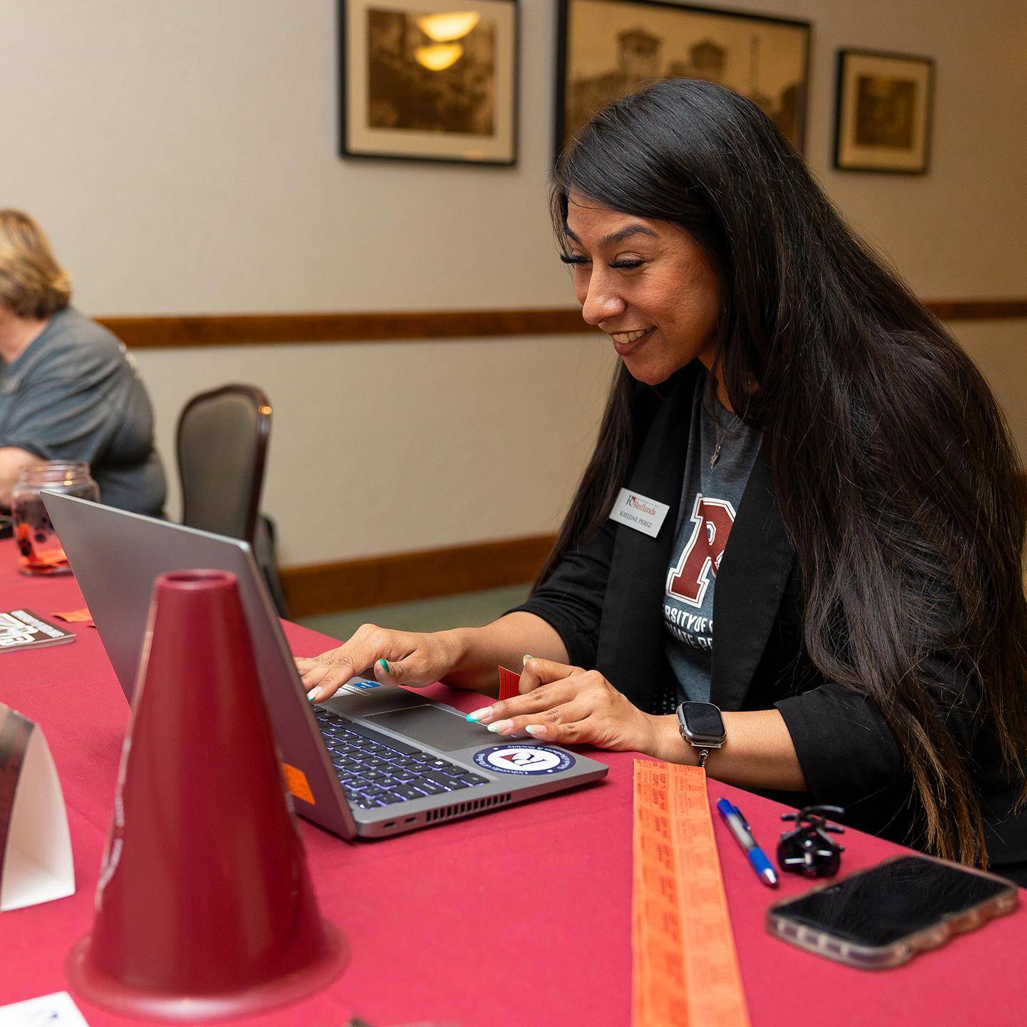 a person sitting at a table using a laptop