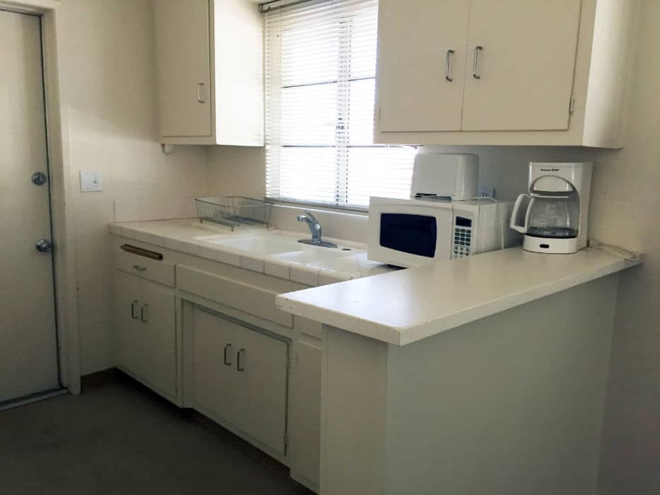 a kitchen with white cabinets and white appliances