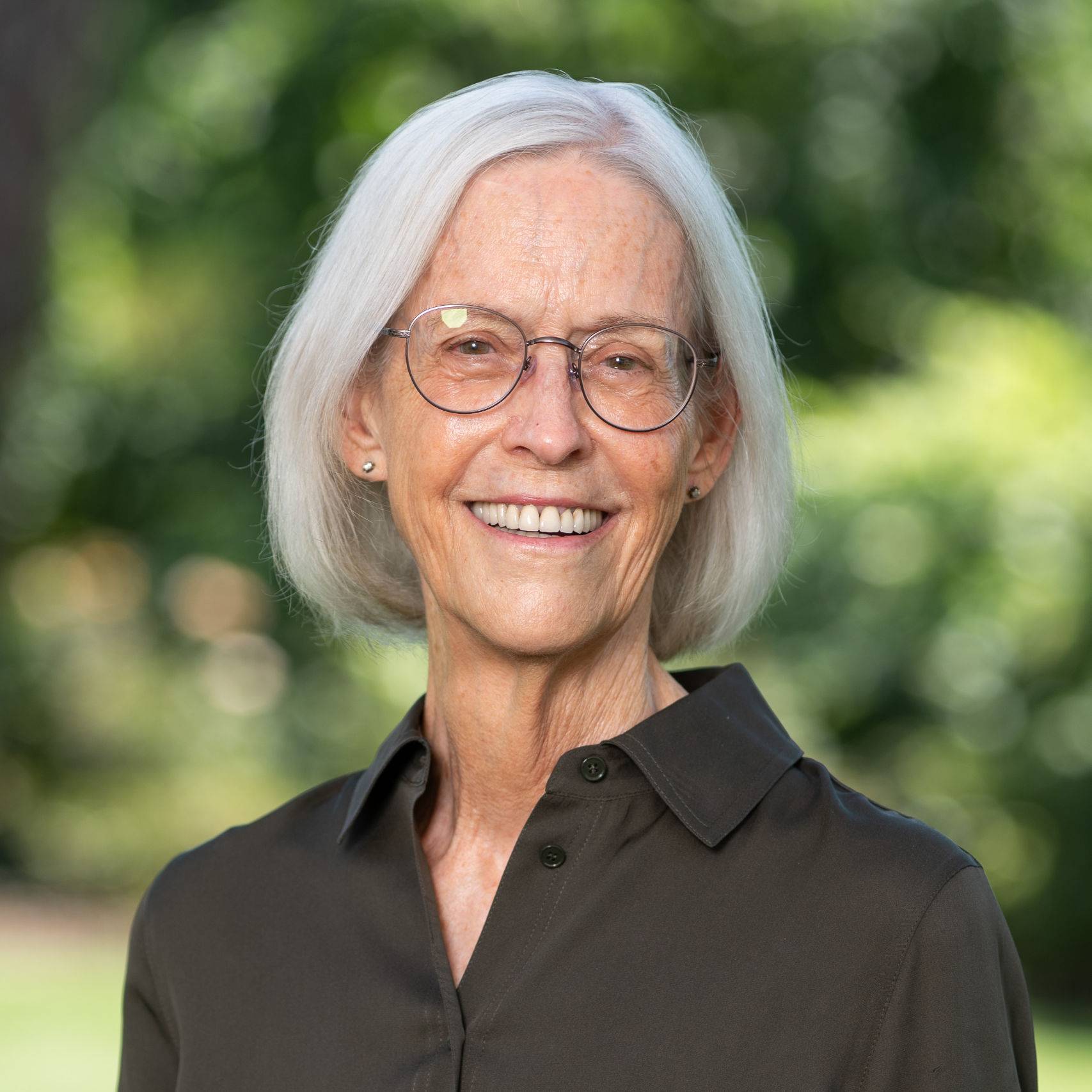 a person with glasses smiling