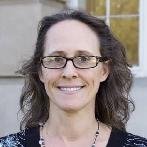 a person wearing glasses and smiling