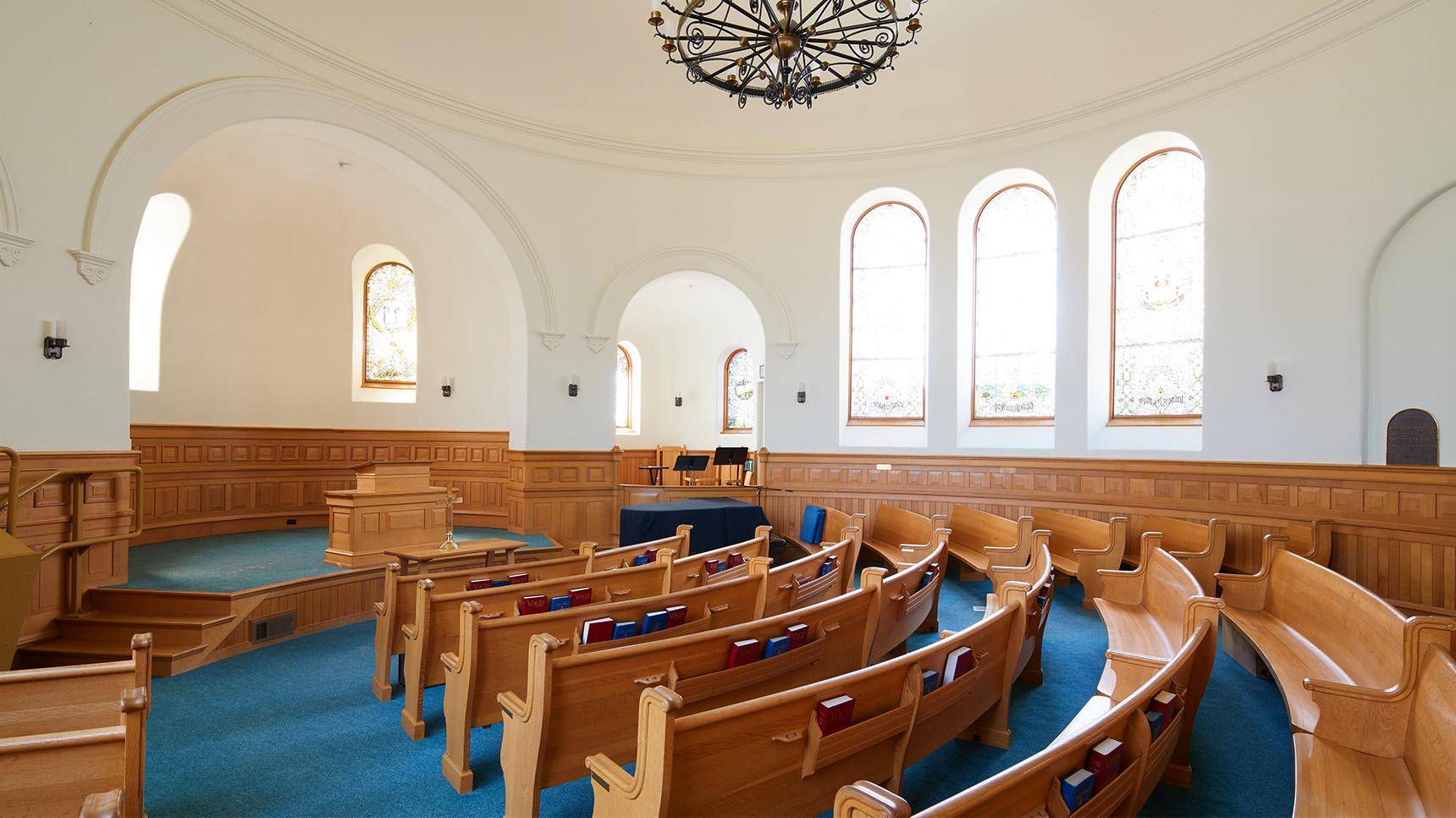 a room with wooden benches and a chandelier