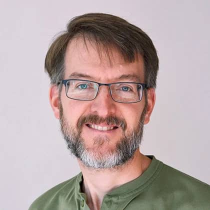 a person with glasses smiling