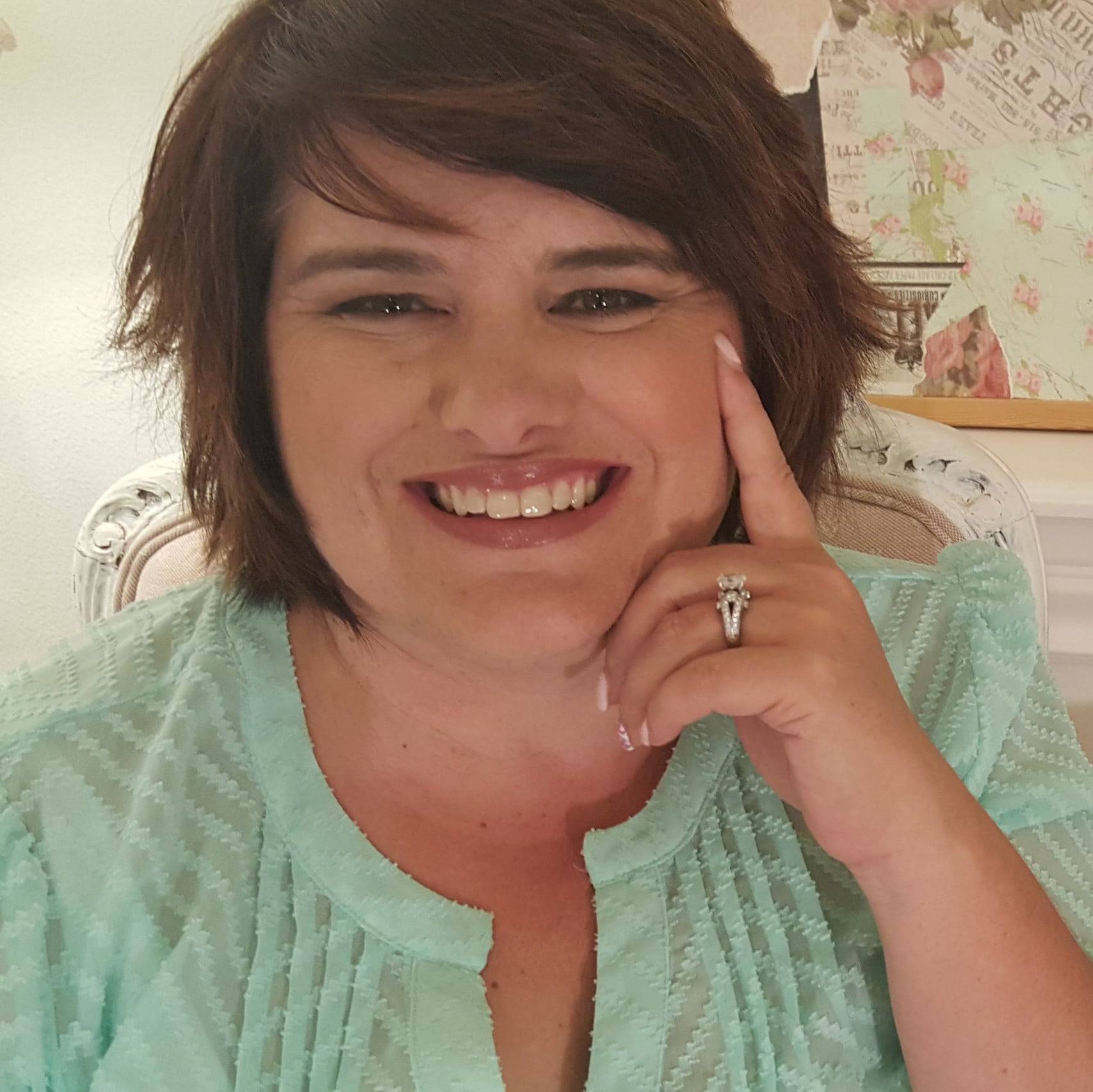 a person smiling with her hand on her face