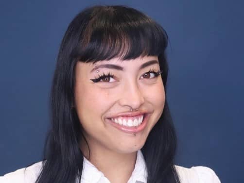 a person with piercings and nose ring smiling