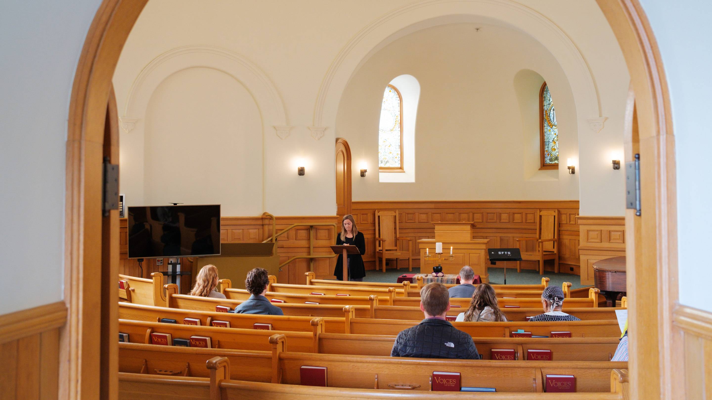 a person standing at a podium in a church
