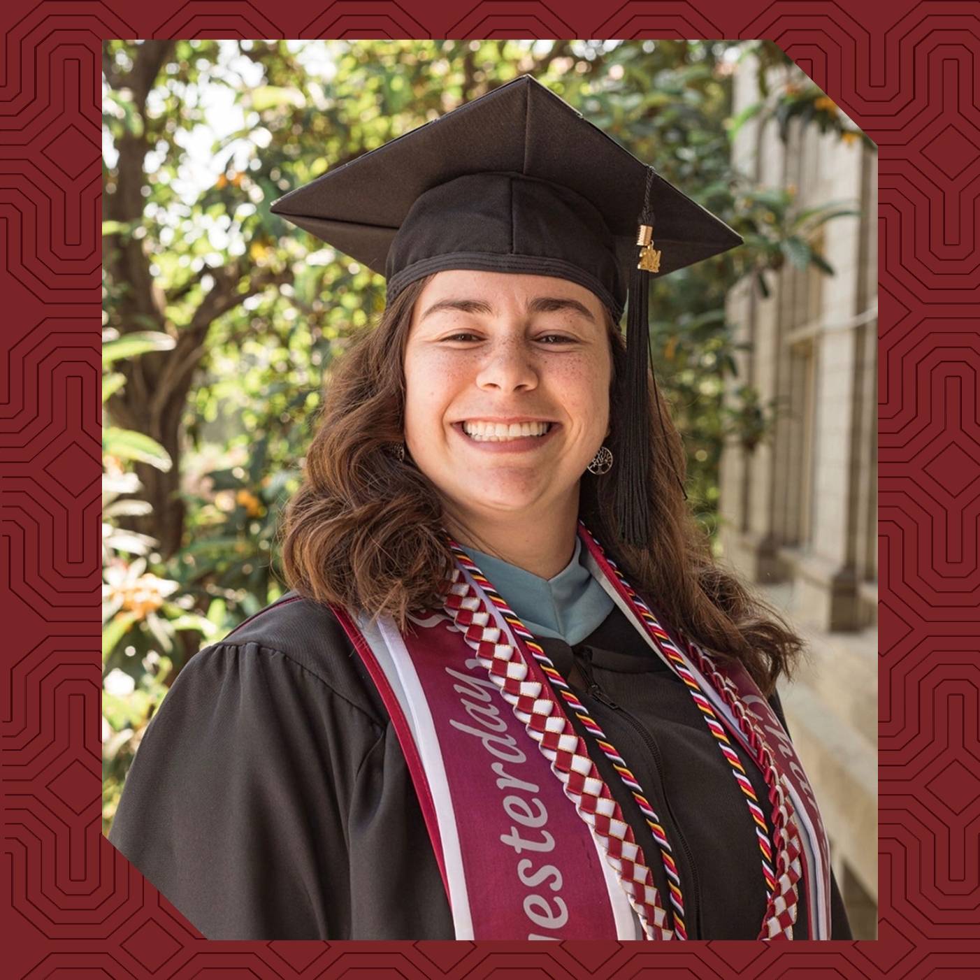 Higher Education and Student Affairs alumna Alicia Reyes ’24 poses in graduation regalia on the University of Redlands campus.