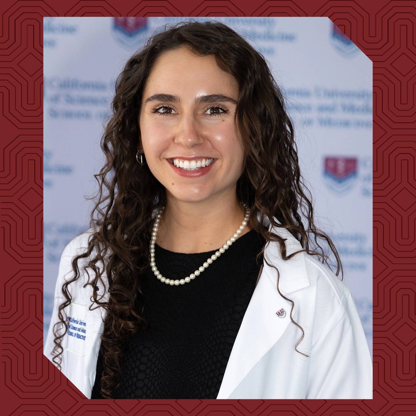 a person with long curly hair wearing a white lab coat