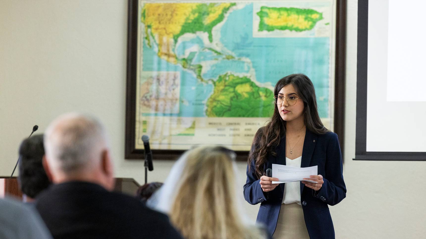 a person holding a piece of paper in front of a group of people