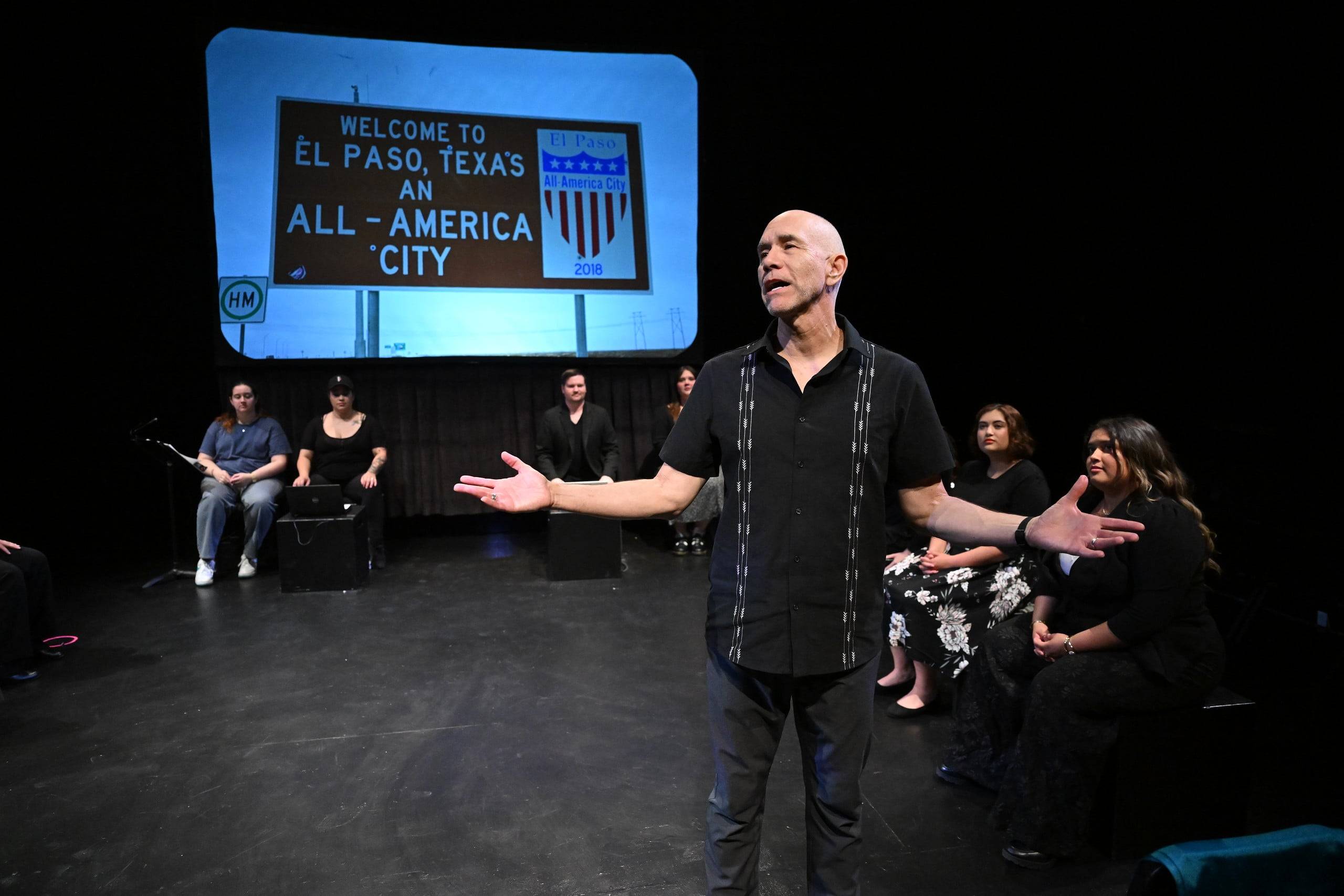 a person standing on a stage with his arms out