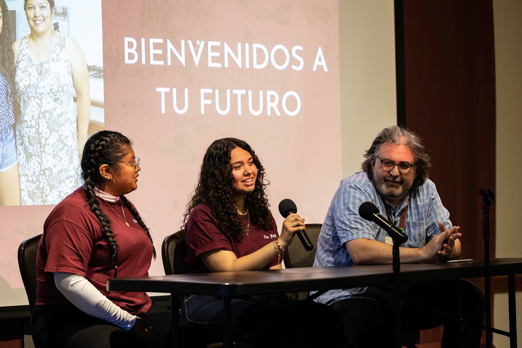 a group of people sitting at a table with microphones