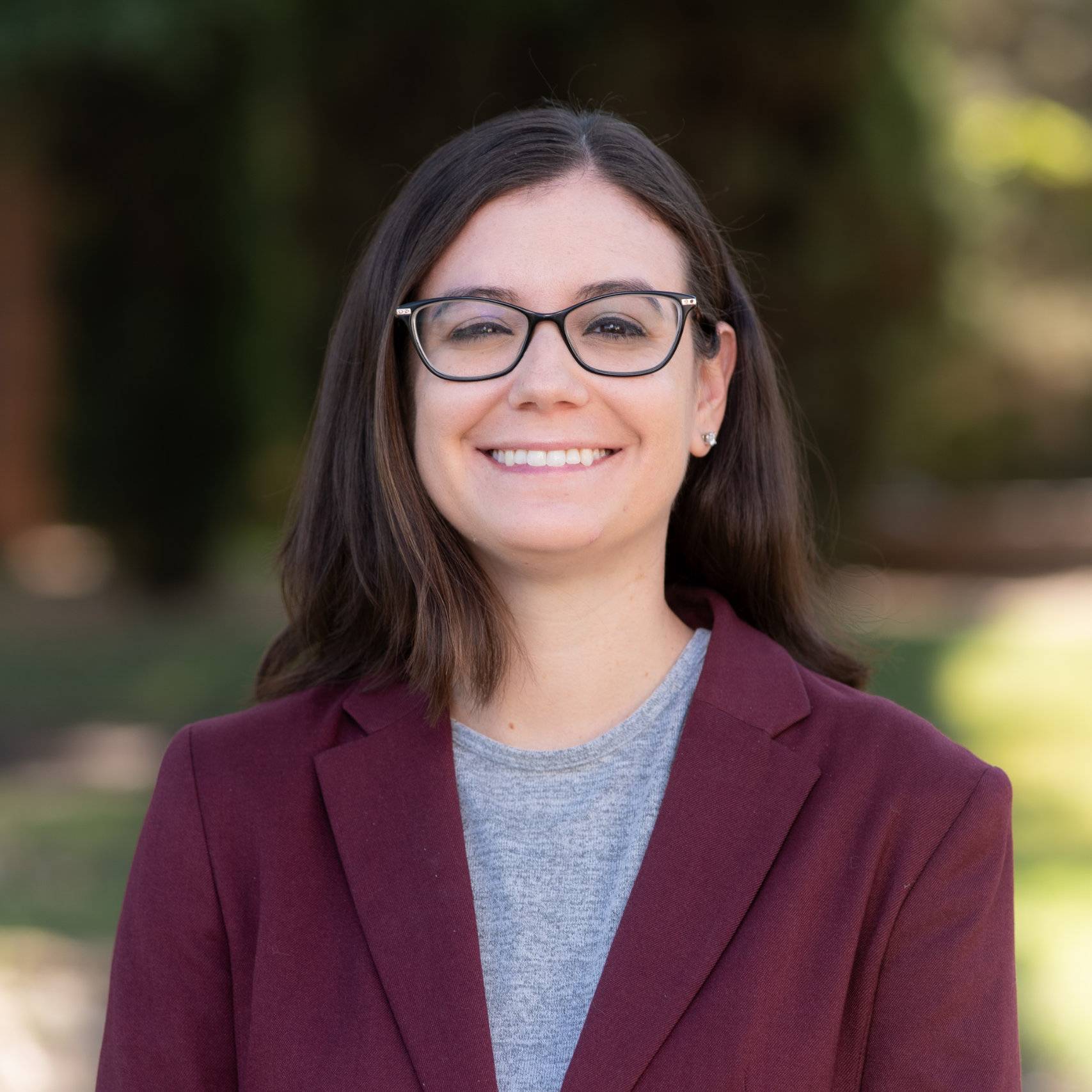 a person wearing glasses and a red blazer